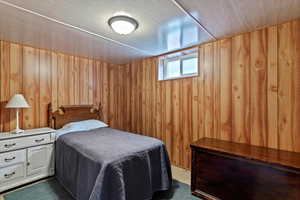 Carpeted bedroom with wood walls
