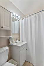 Full bathroom featuring vanity, light tile patterned floors, and curtained shower