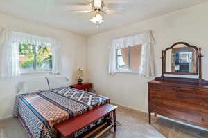 Bedroom with light carpet and a ceiling fan