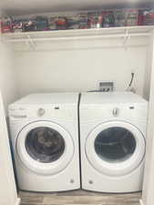 Washroom with wood finished floors and washer and dryer