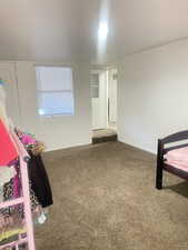 Unfurnished bedroom featuring baseboards and carpet