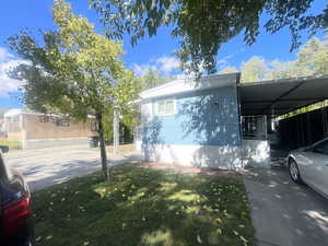 View of home's exterior with a yard and an attached carport