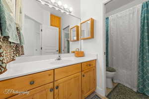 Bathroom with vanity, curtained shower, and light tile patterned flooring