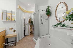 Bathroom with vanity, a stall shower, a bath, and light tile patterned floors