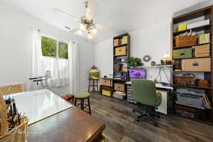 Office space featuring dark wood-style flooring, ceiling fan, and washer / clothes dryer