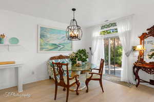 Dining space featuring light wood-type flooring and a chandelier