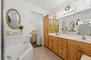 Bathroom with a garden tub, double vanity, a shower stall, and light tile patterned floors