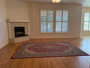 Unfurnished living room with light wood-style floors and a tiled fireplace