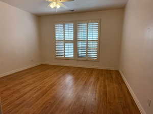 Empty room featuring a ceiling fan and light wood-style floors