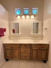 Bathroom featuring double vanity and light tile patterned flooring