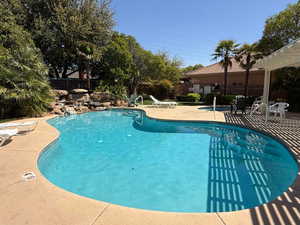 Community pool with a pergola and a patio