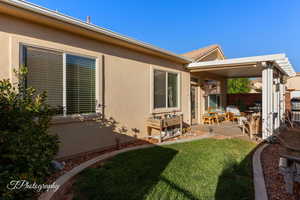 Rear view of property featuring a patio, stucco siding, and a yard