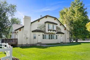Rear view of Condo with a chimney and stucco siding.