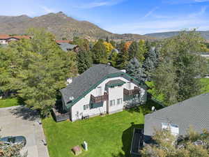 Aerial view of property and surrounding area featuring a mountainous background