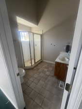 3/4 bathroom featuring vanity, a shower stall, and light tile patterned flooring