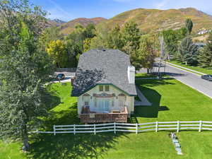 Rear view of property featuring a mountain view, a fenced backyard, an outdoor hangout area, and a chimney