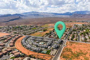 Aerial overview of property's location featuring a mountain backdrop and nearby suburban area