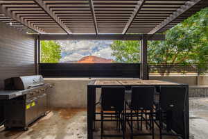 View of patio featuring area for grilling, a mountain view, outdoor dining area, and a pergola