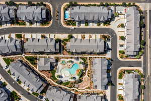 Aerial view of property and surrounding area with a pool area and nearby suburban area