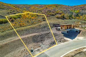 Aerial view of property and surrounding area featuring property parcel outlined and a mountainous background