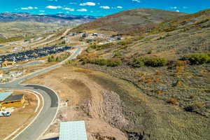 Aerial view of property and surrounding area featuring a mountain backdrop