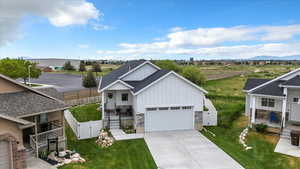 View of front of property featuring a gate, board and batten siding, driveway, a residential view, and a garage