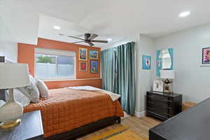 Bedroom featuring light wood-type flooring, a textured ceiling, a ceiling fan, and recessed lighting