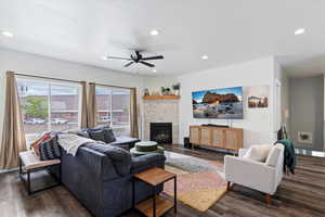 Living room featuring dark wood finished floors, recessed lighting, a fireplace, and ceiling fan