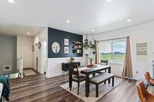 Dining space with wood finished floors, recessed lighting, and a wainscoted wall