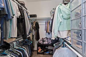 Walk in closet featuring dark carpet