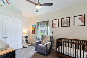 Carpeted bedroom with a nursery area, ceiling fan, and a closet