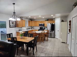 Large kitchen with middle island, tiled flooring, two pantries, gas stove and french doors to back patio