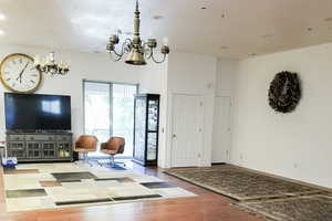 Living area with a chandelier, wood finished floors, and recessed lighting