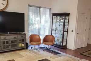 Large Greatroom with dark wood finished floors and baseboards—access to the Elevator.