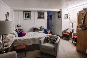 Carpeted bedroom with a textured ceiling and a closet