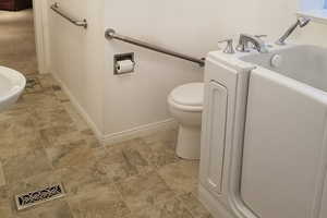 Bathroom featuring light stone finish floors