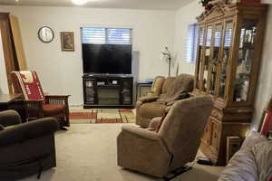 Living area with healthy amount of natural light and light colored carpet