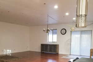 Unfurnished dining area featuring radiator, dark wood-style floors, a chandelier, and recessed lighting