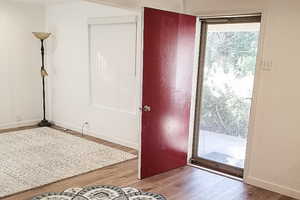 Doorway to outside with wood finished floors and baseboards