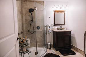 Full bath featuring a stall shower and vanity