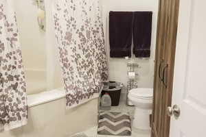 Bathroom featuring tile patterned flooring and shower / bath combination with curtain