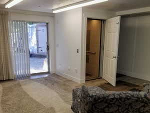 This unfurnished room features hardwood floors and access to the outdoors.