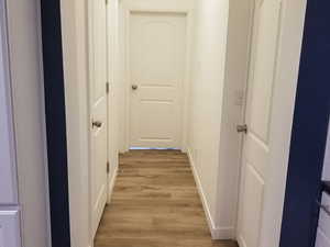Corridor with baseboards and light wood-type flooring