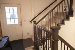 Foyer with baseboards and stairway