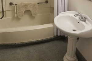 Full bathroom with shower / bath combo and a sink