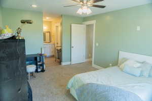 Carpeted bedroom with ceiling fan and ensuite bathroom