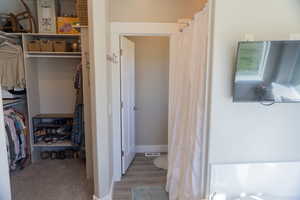 Master bathroom and closet featuring LVP finished floors and wood baseboards