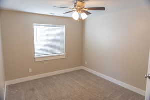 Basement apartment second bedroom with ceiling fan and a textured ceiling