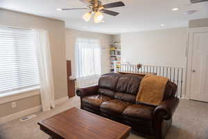 Living area featuring carpet floors, a ceiling fan, and recessed lighting