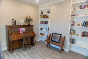 Living area featuring built in shelves and light wood-style floors